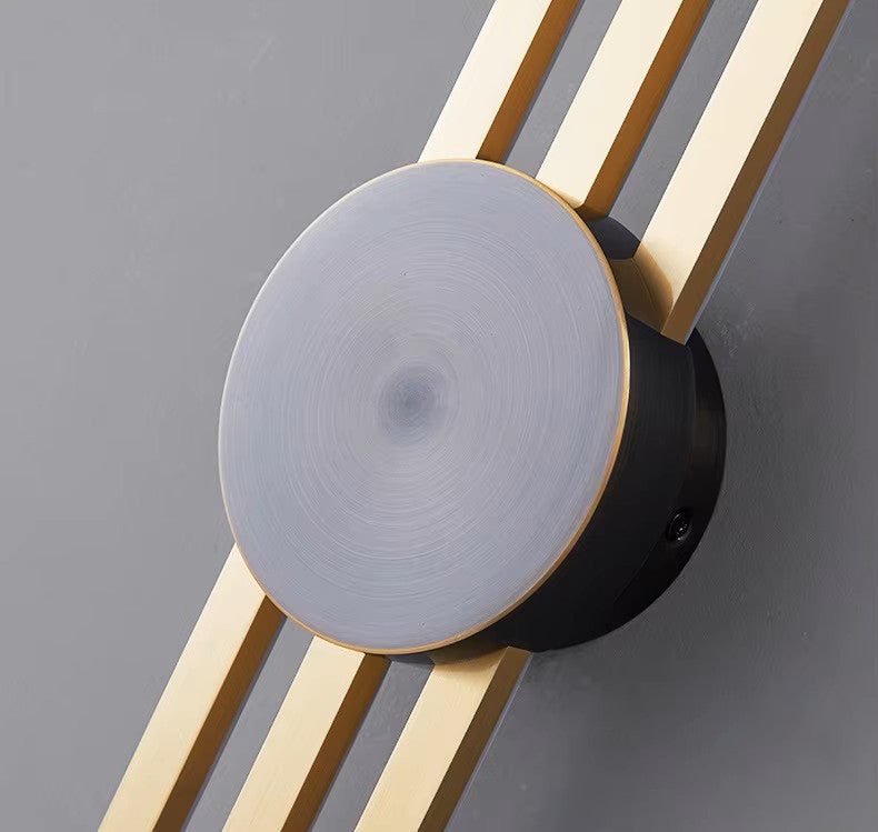 Modern wall light fixture with gold accents on a gray background