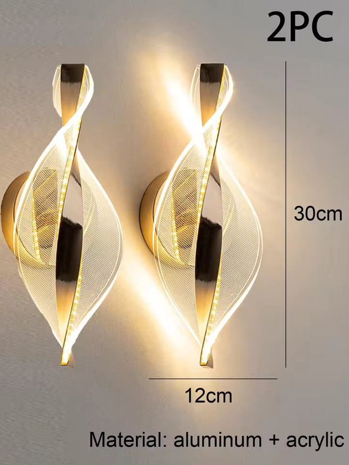 Two gold wall sconces with dimensions and material information on a neutral background