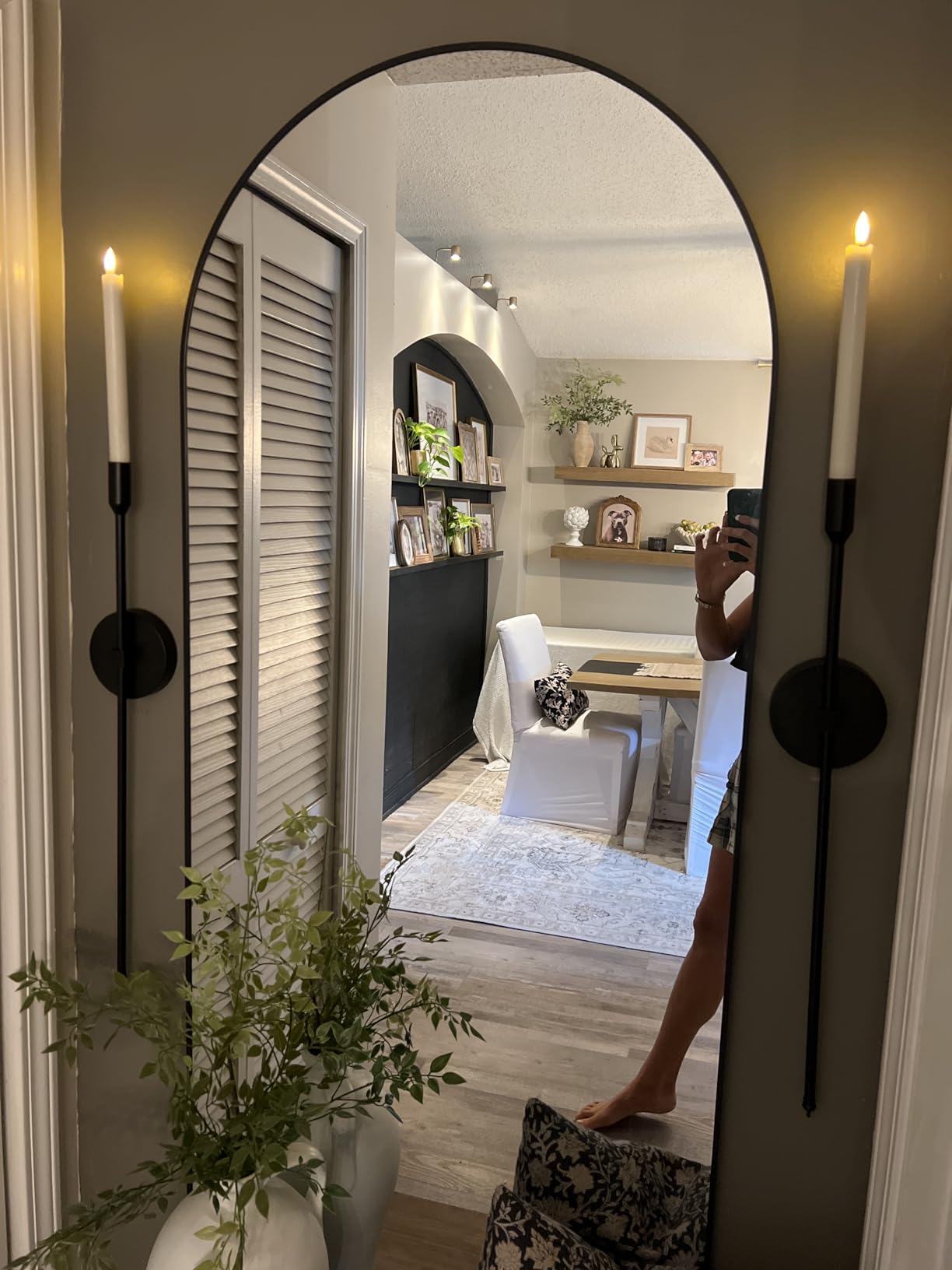 Architectural interior view through a large round mirror with decorative elements.