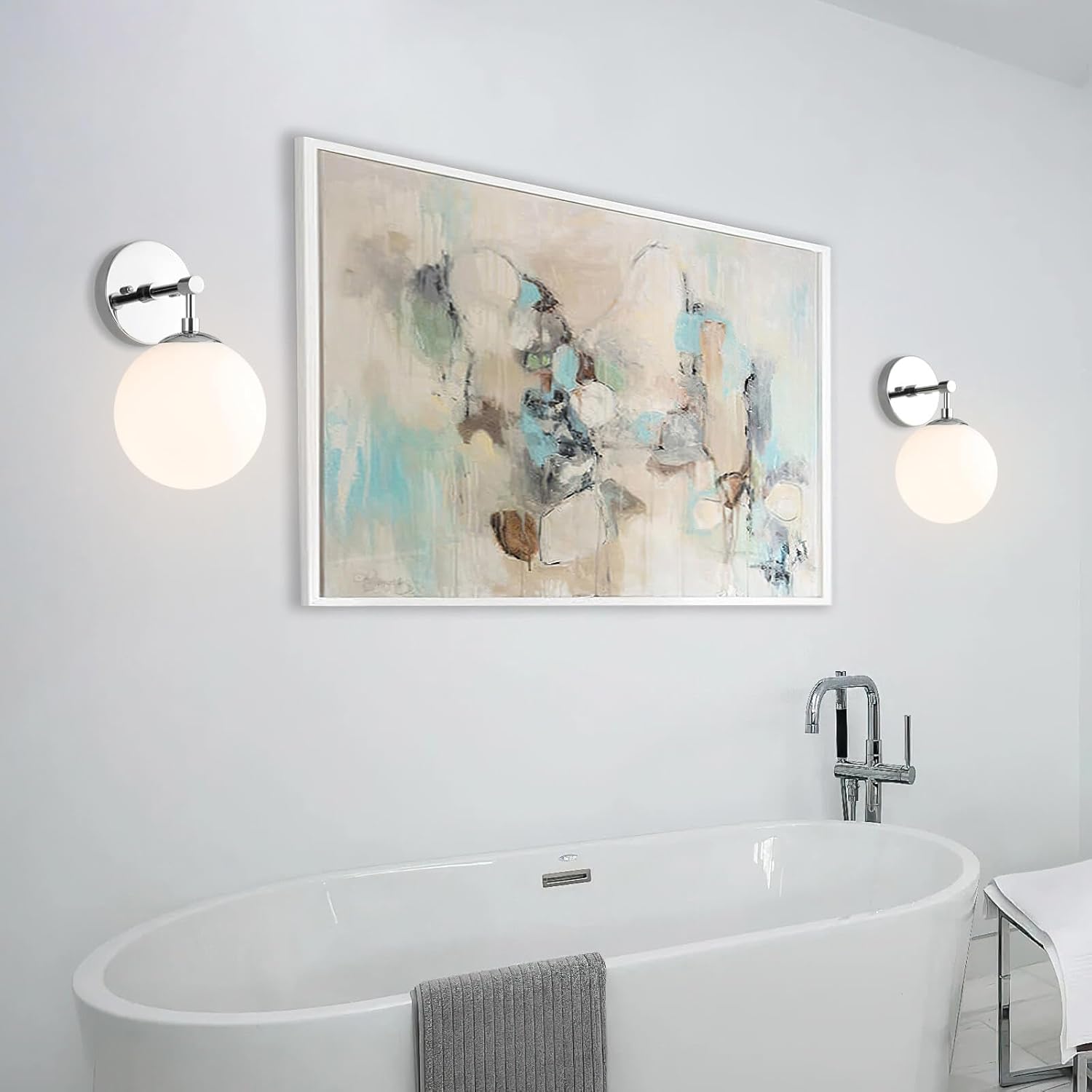 Bathroom interior with a bathtub, abstract art on the wall, and two wall lights.
