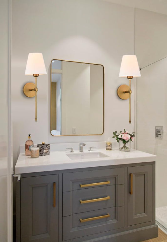 Bathroom vanity with gray cabinets, gold fixtures, and wall lights.