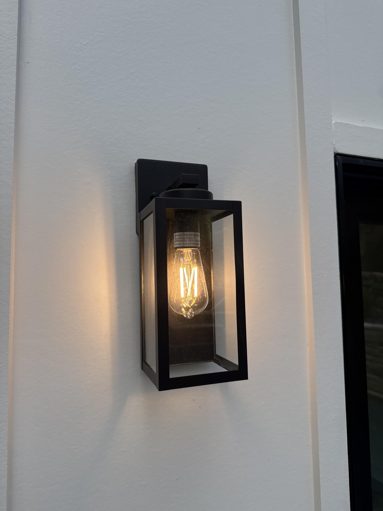 Black outdoor wall light fixture on a white wall