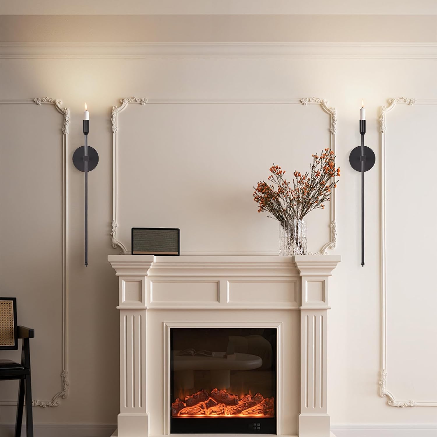 Decorative fireplace with a mirror above it, candles on either side, and a vase with flowers.