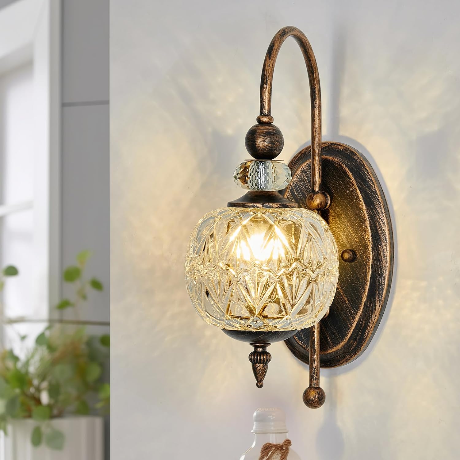 Decorative wall lamp with glass shade and bronze finish on a light background