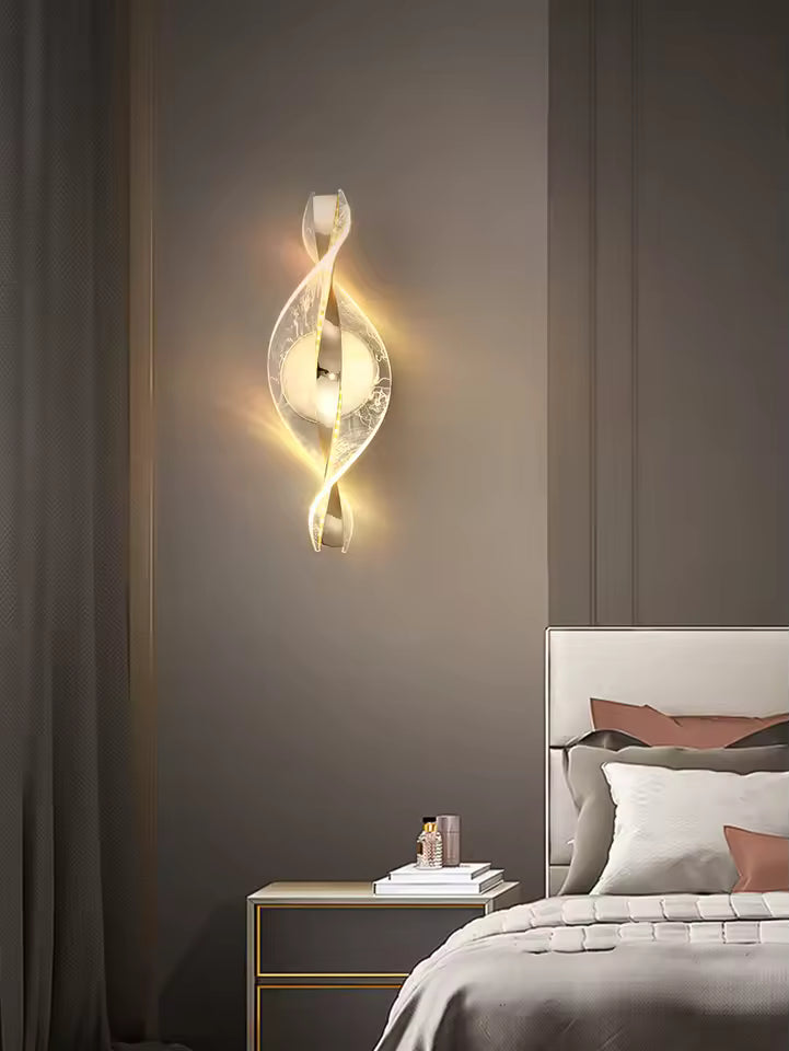 Decorative wall sconce on a gray wall above a bed with a nightstand.