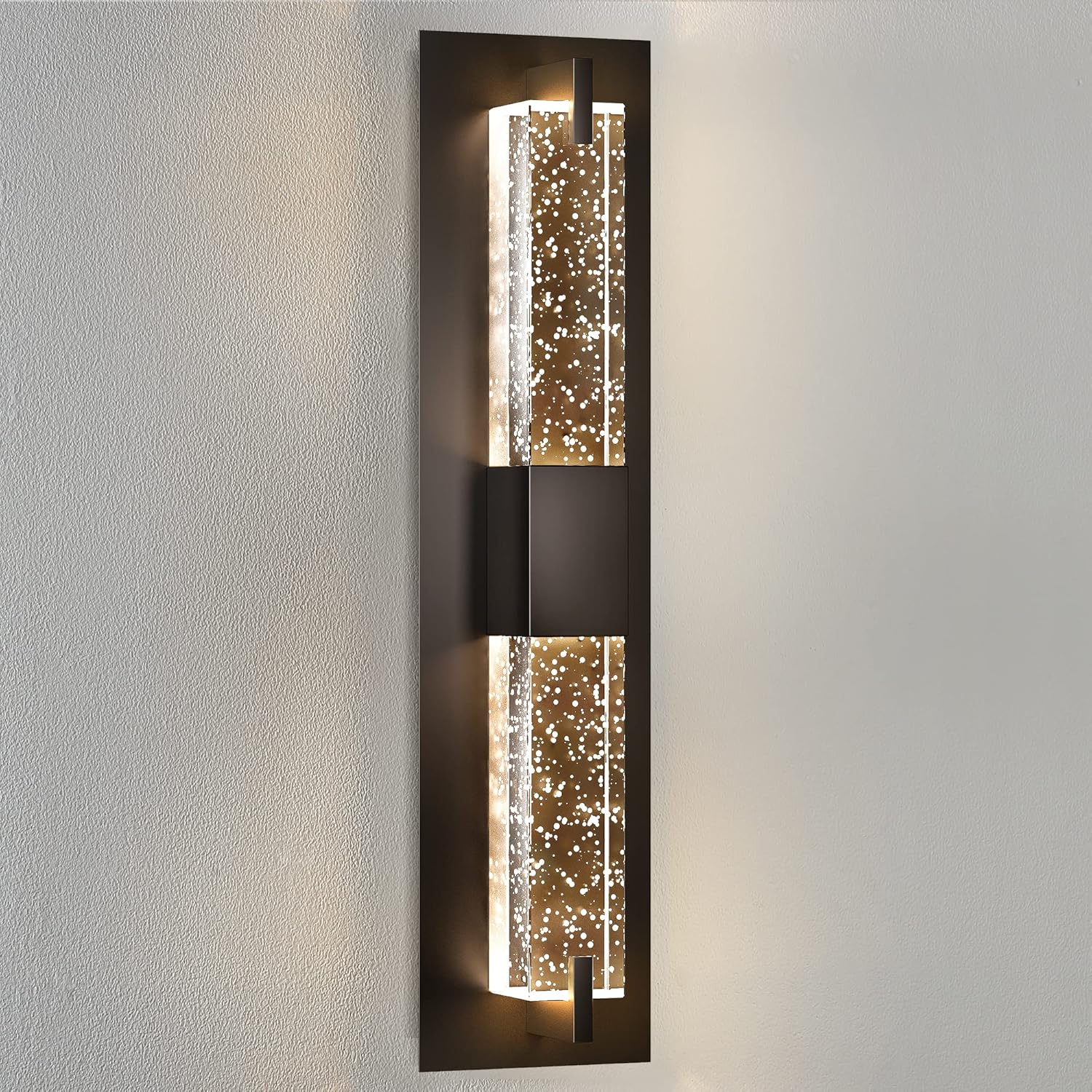 Decorative wall sconce with glass panels on a plain wall