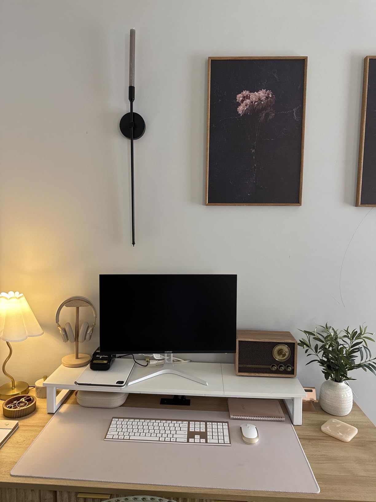 Modern home office desk setup with computer monitor, keyboard, and decorative items.