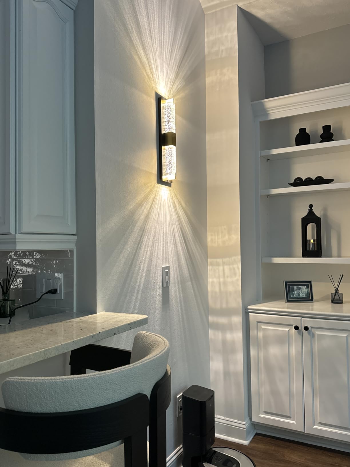 Modern interior design with wall sconce, shelves, and a chair.