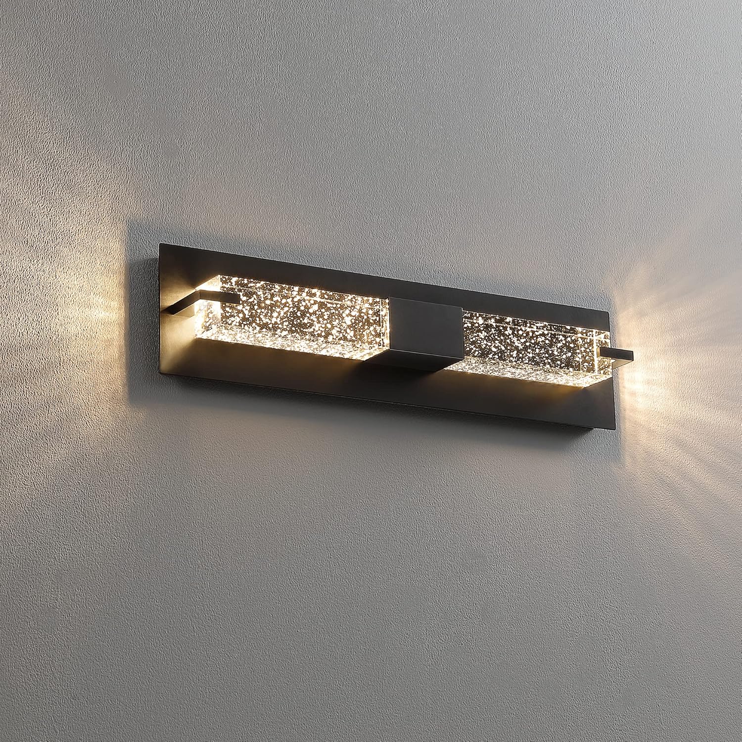 Modern wall-mounted light fixture with crystal accents on a gray wall.