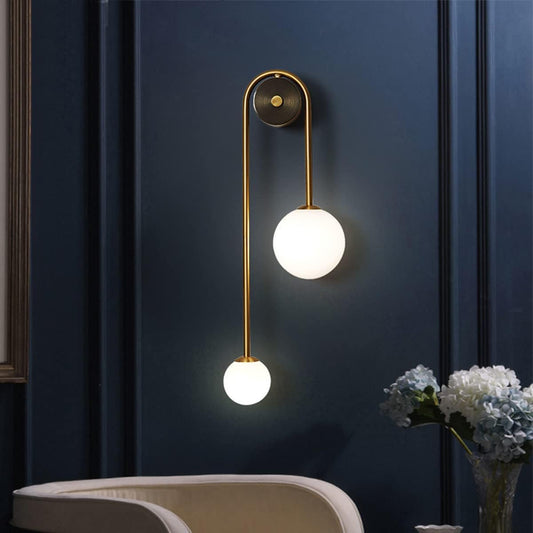 Modern wall lamp with two spherical lights on a dark blue wall.