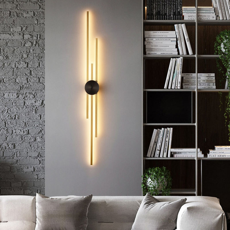 Modern wall light fixture in a living room setting with a bookshelf and sofa.