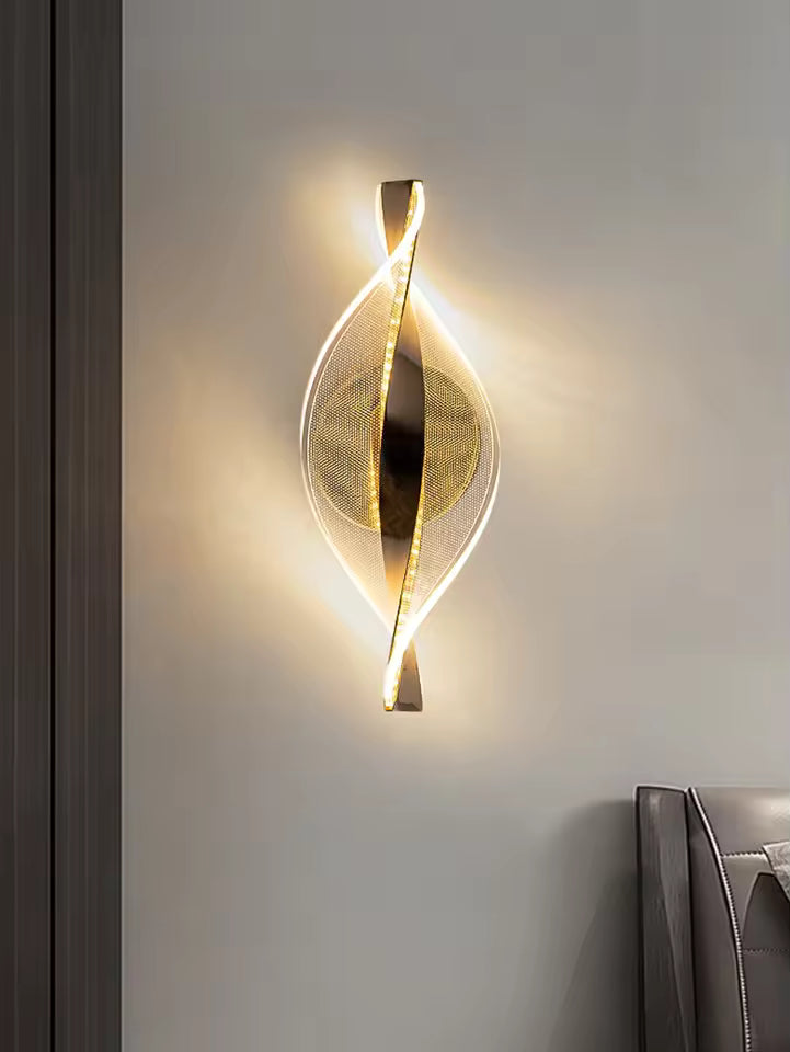 Modern wall sconce with a gold finish on a neutral wall.