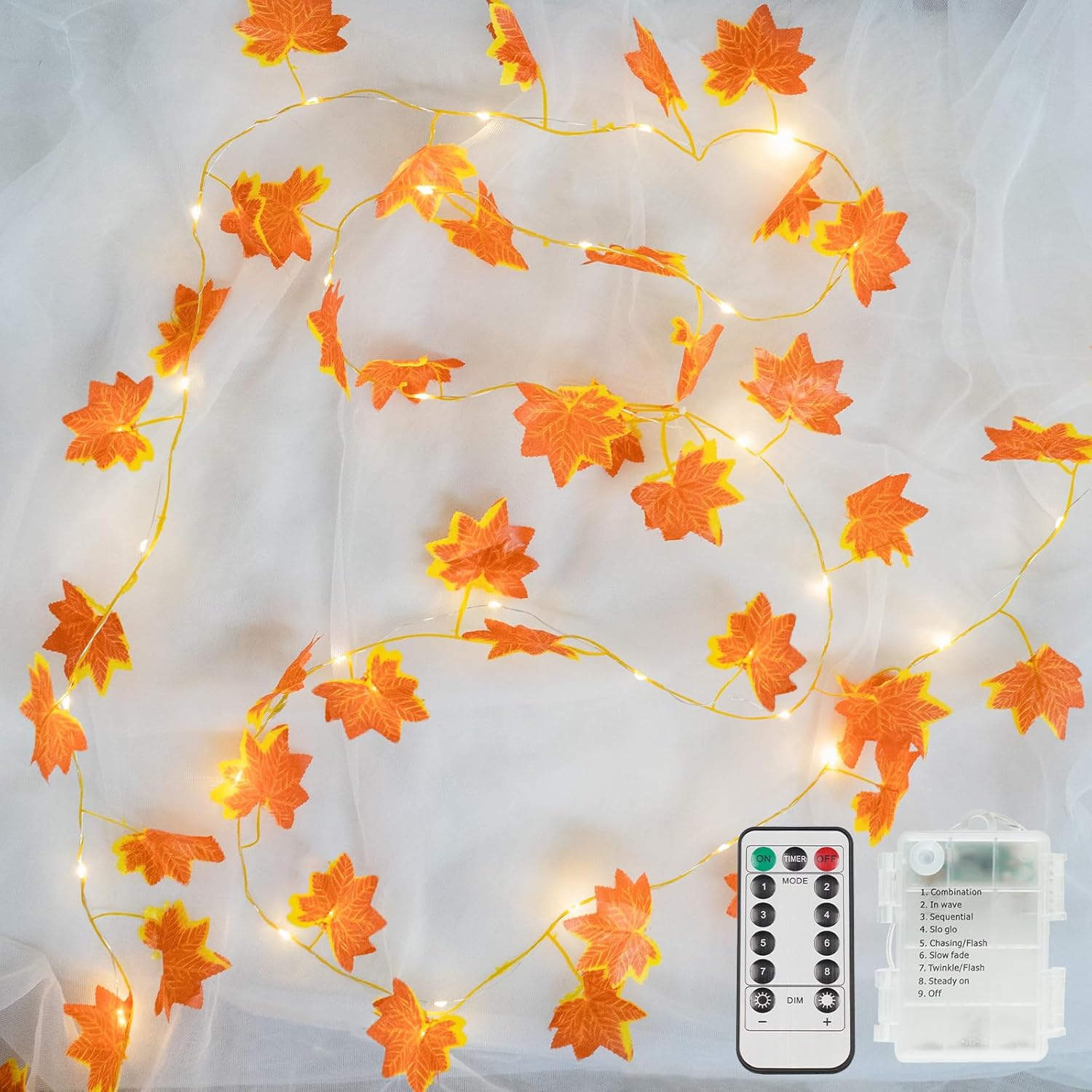 String lights with leaf decorations and remote control on a white background
