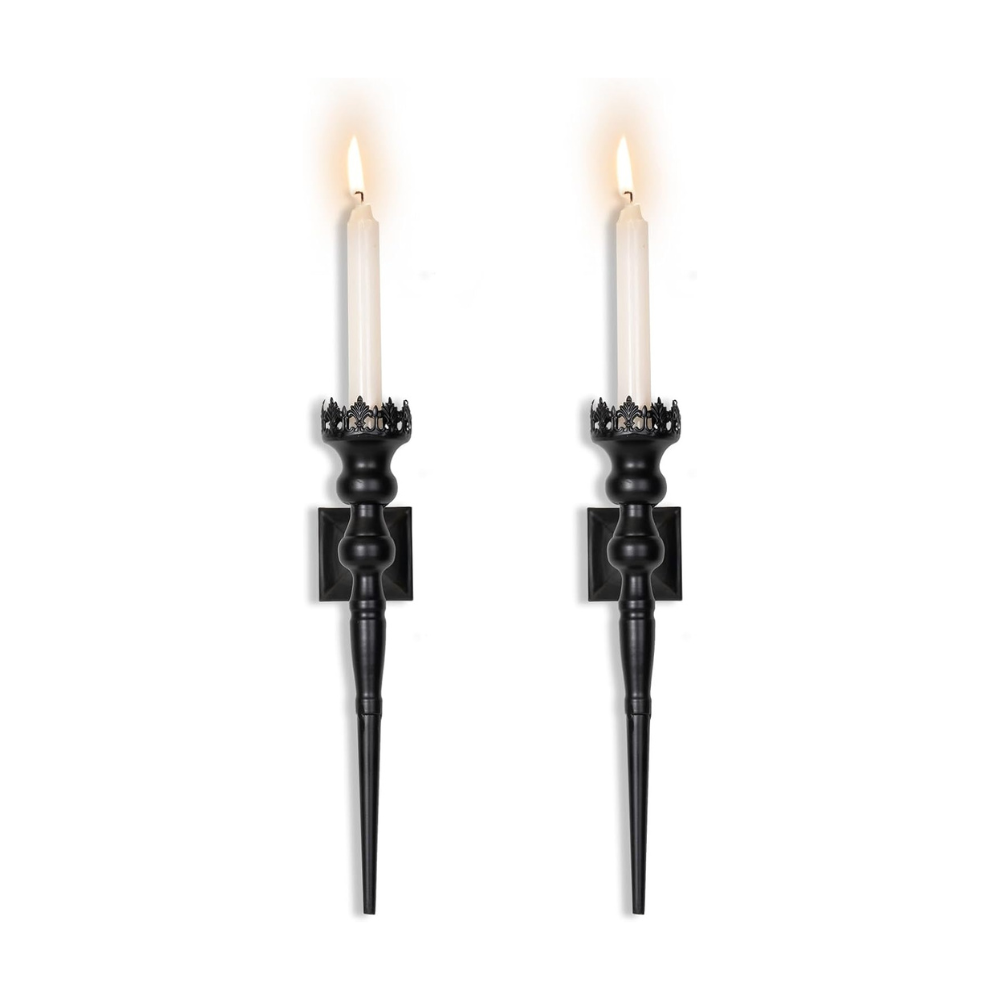 Two black candle holders with lit candles on a white background