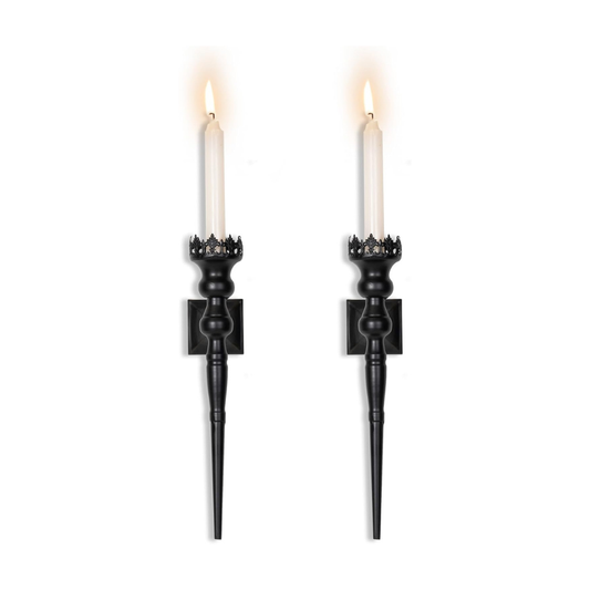 Two black candle holders with lit candles on a white background