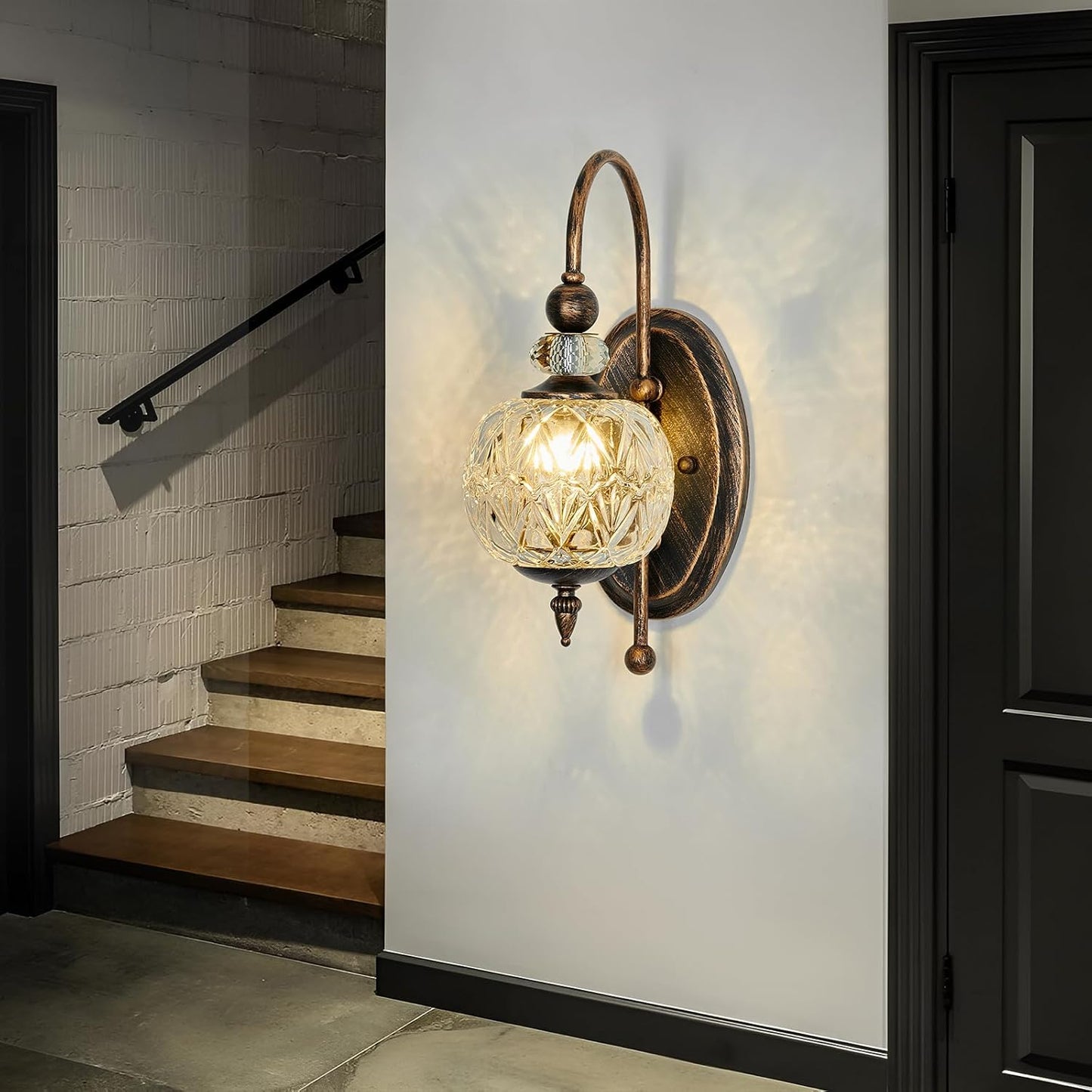 Wall-mounted lamp with a decorative glass shade in a home setting.