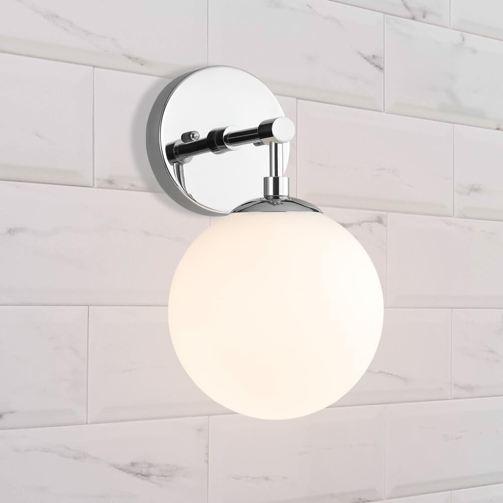 Wall-mounted light fixture with a round glass shade on a tiled wall.