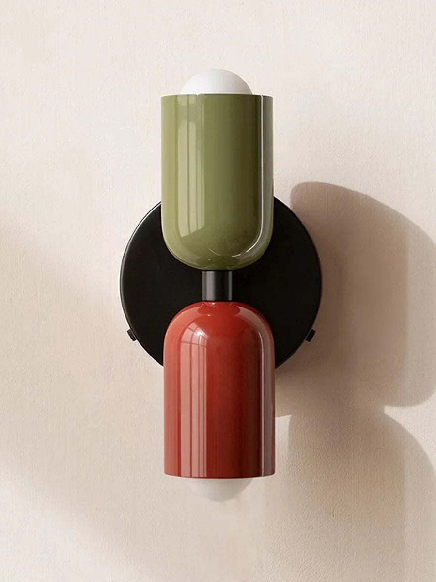 Wall-mounted light fixture with green and red design on a beige background