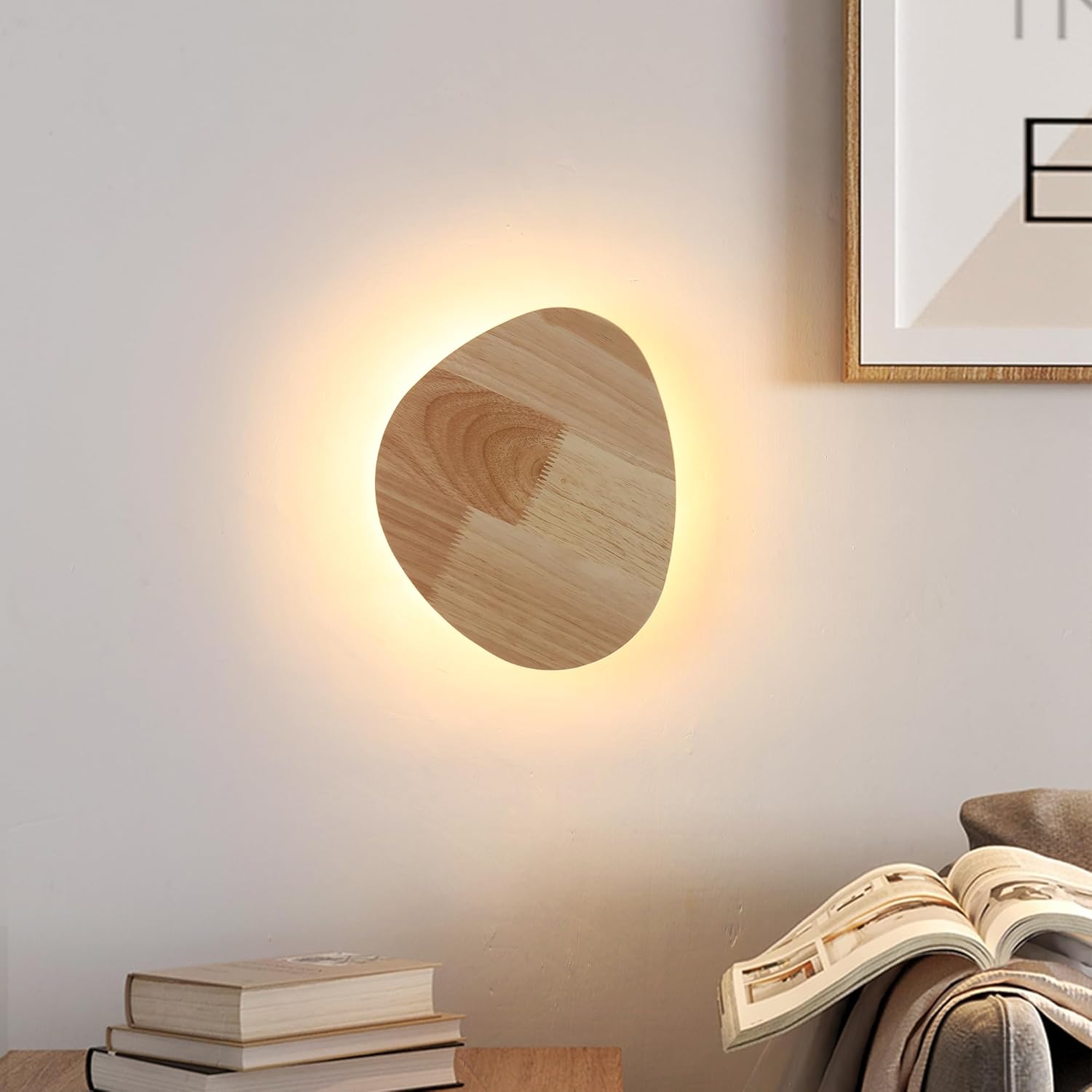 Wooden wall light fixture on a wall with books and an open book in the foreground.